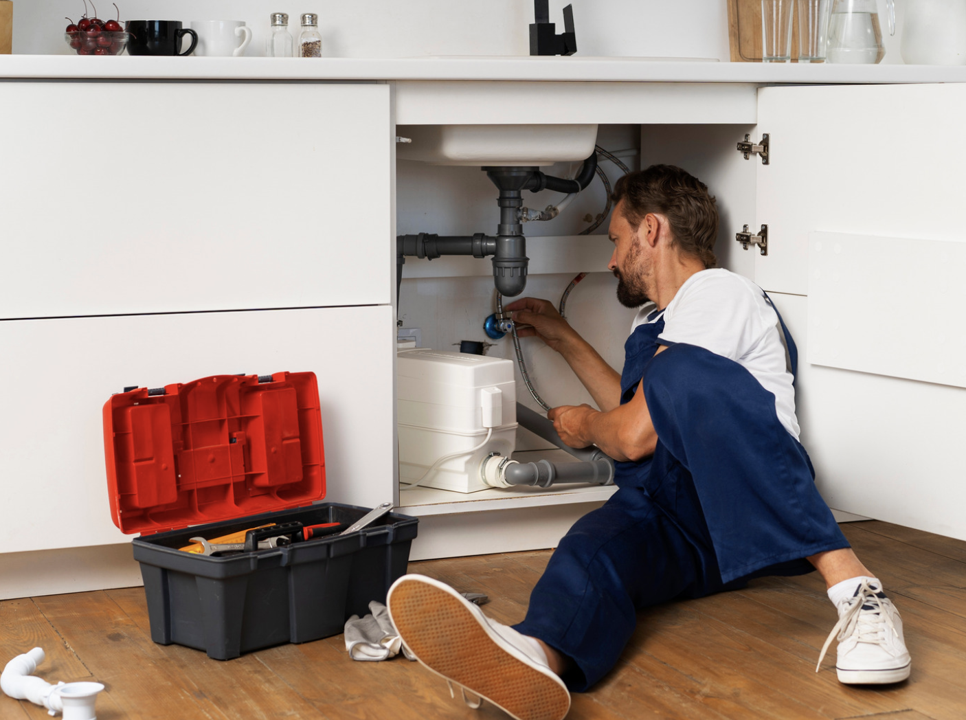 Plumber working under a kitchen cabinet